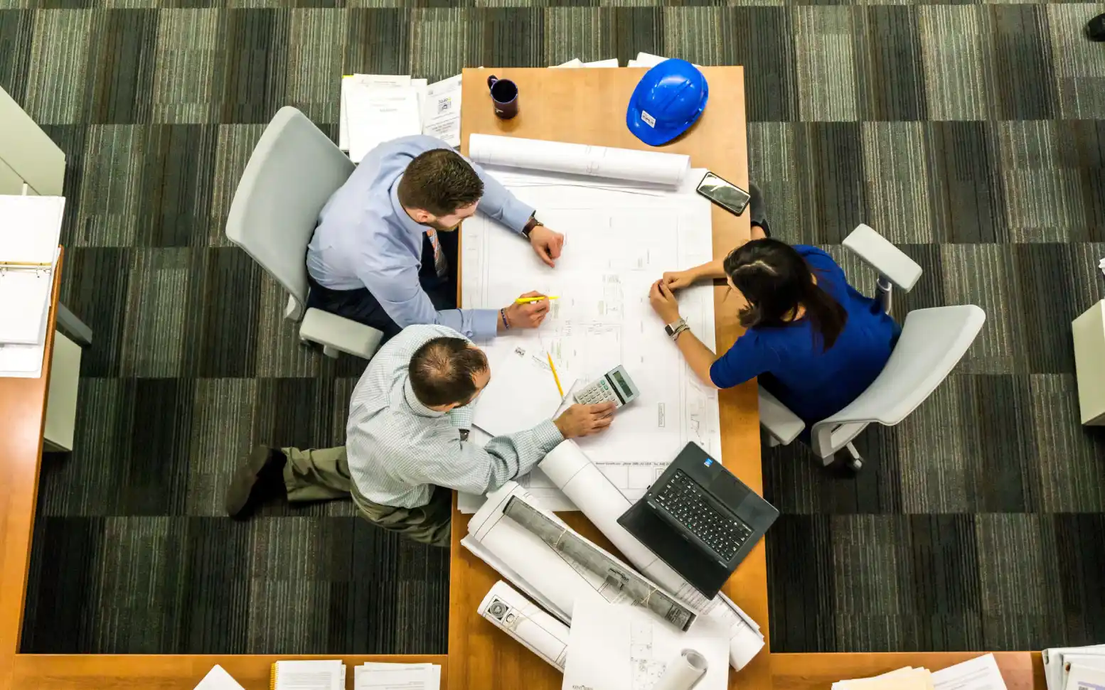 Three people sitting at a table with papers on it