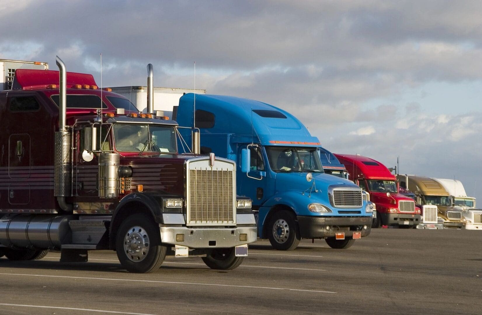 A group of trucks are parked on the side of the road.
