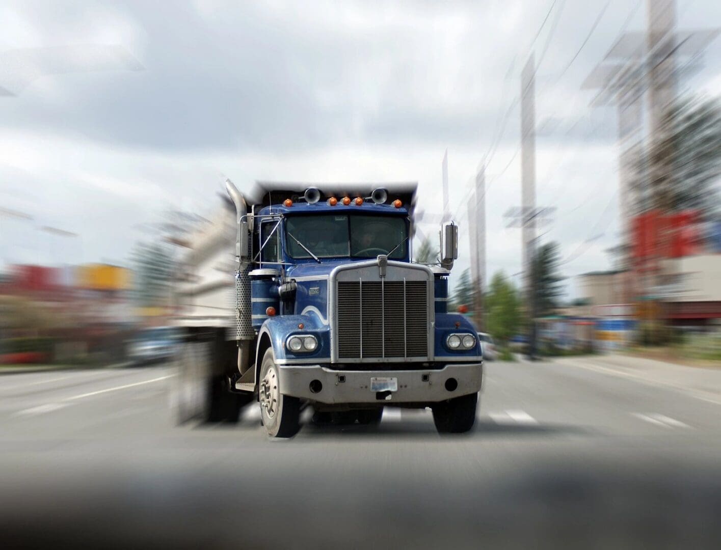 A truck driving down the street with a blurry background.