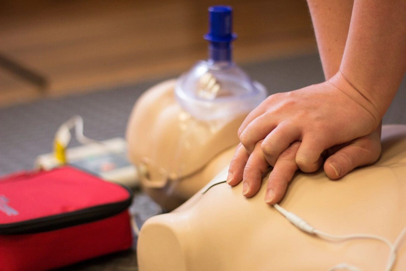 A person is holding their hands on the chest of an aed.